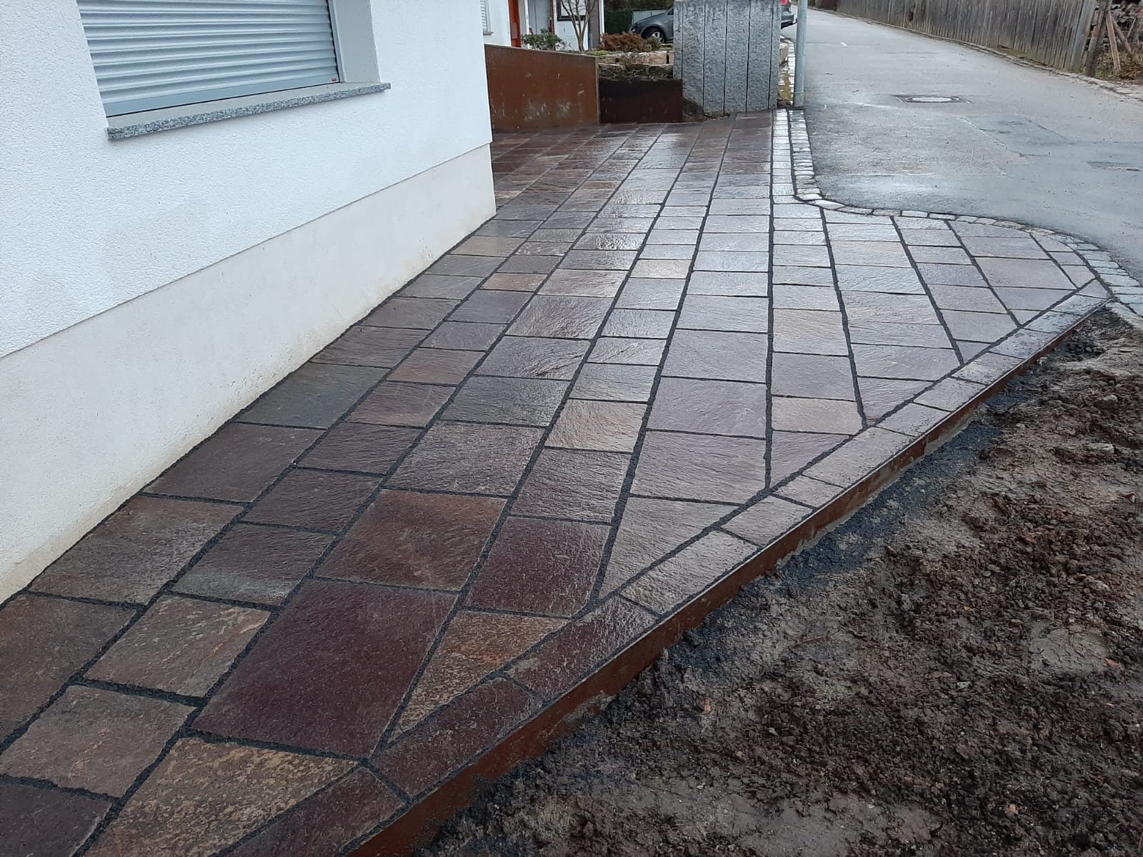 Detailansicht des Porphyr-Natursteinbelags mit Granitpflaster-Einfassung