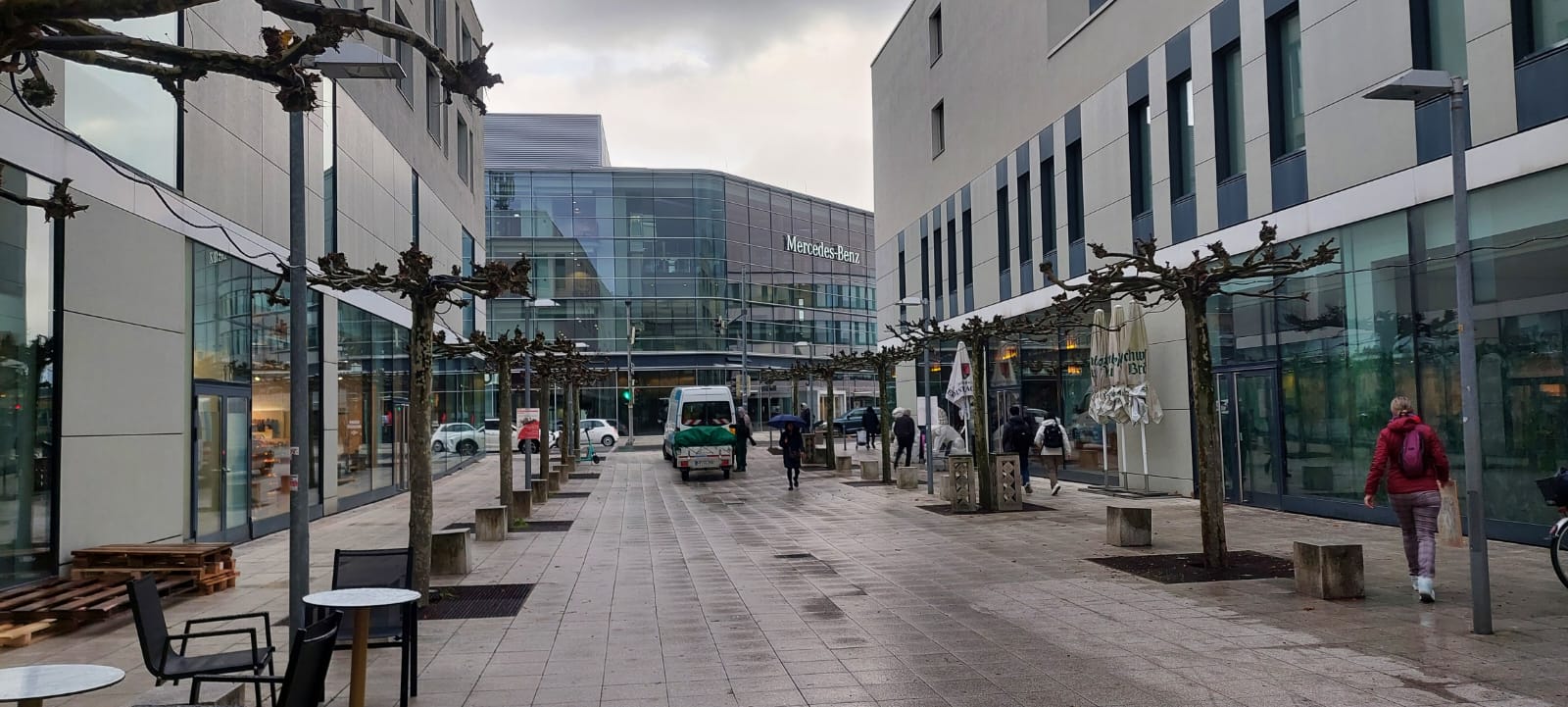 Außenanlage eines Einkaufszentrums mit gepflegten Baumstandorten und Pflanzflächen