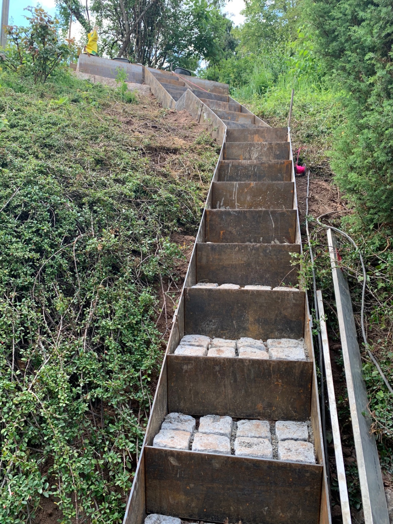 Fertiggestellte Treppenanlage im Hang mit Natursteinpflaster in der Ansicht von unten