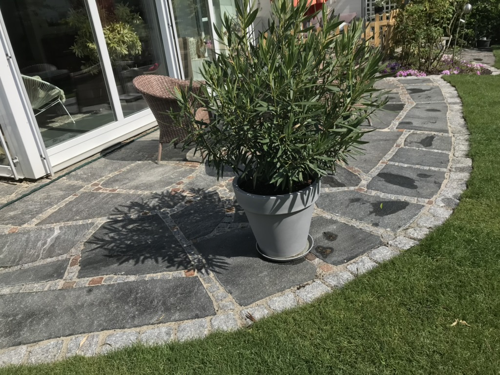 Detailaufnahme der Natursteinterrasse mit Granit-Randstein