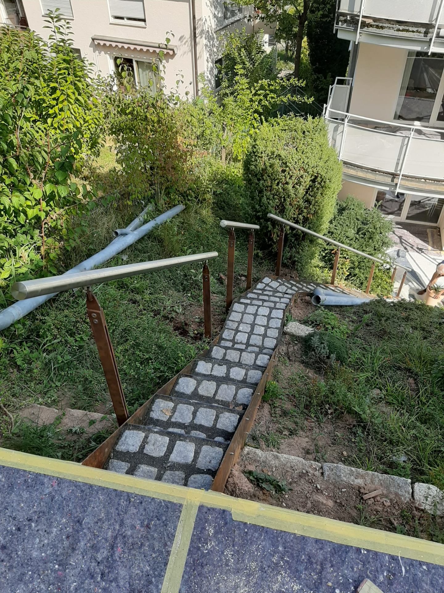 Fertiggestellte Hangtreppe mit Stahleinfassung und Geländer von oben gesehen