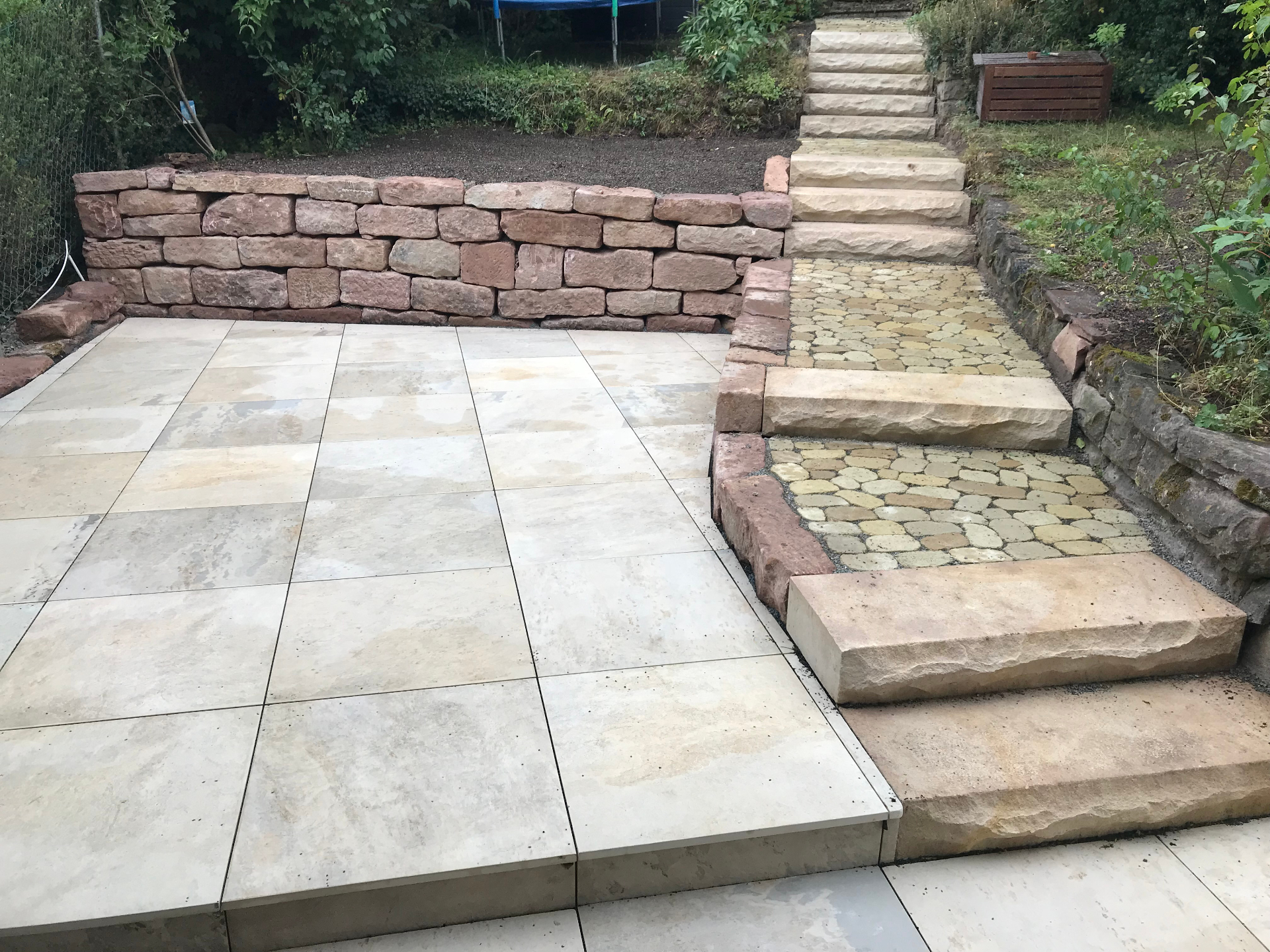 Terrasse mit Natursteinmauer und Treppenanlage