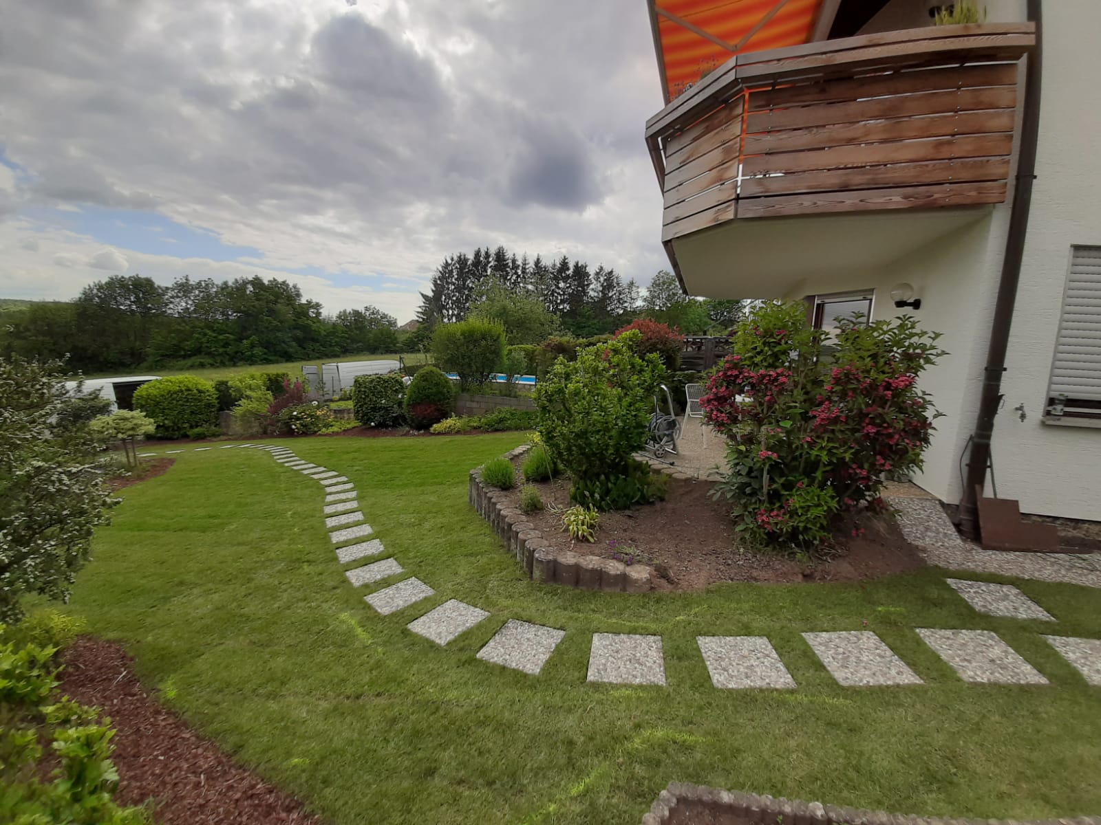 Rasenanlage im Privatgarten mit strukturierter Wegeführung und Pflanzbereichen in Aichtal.