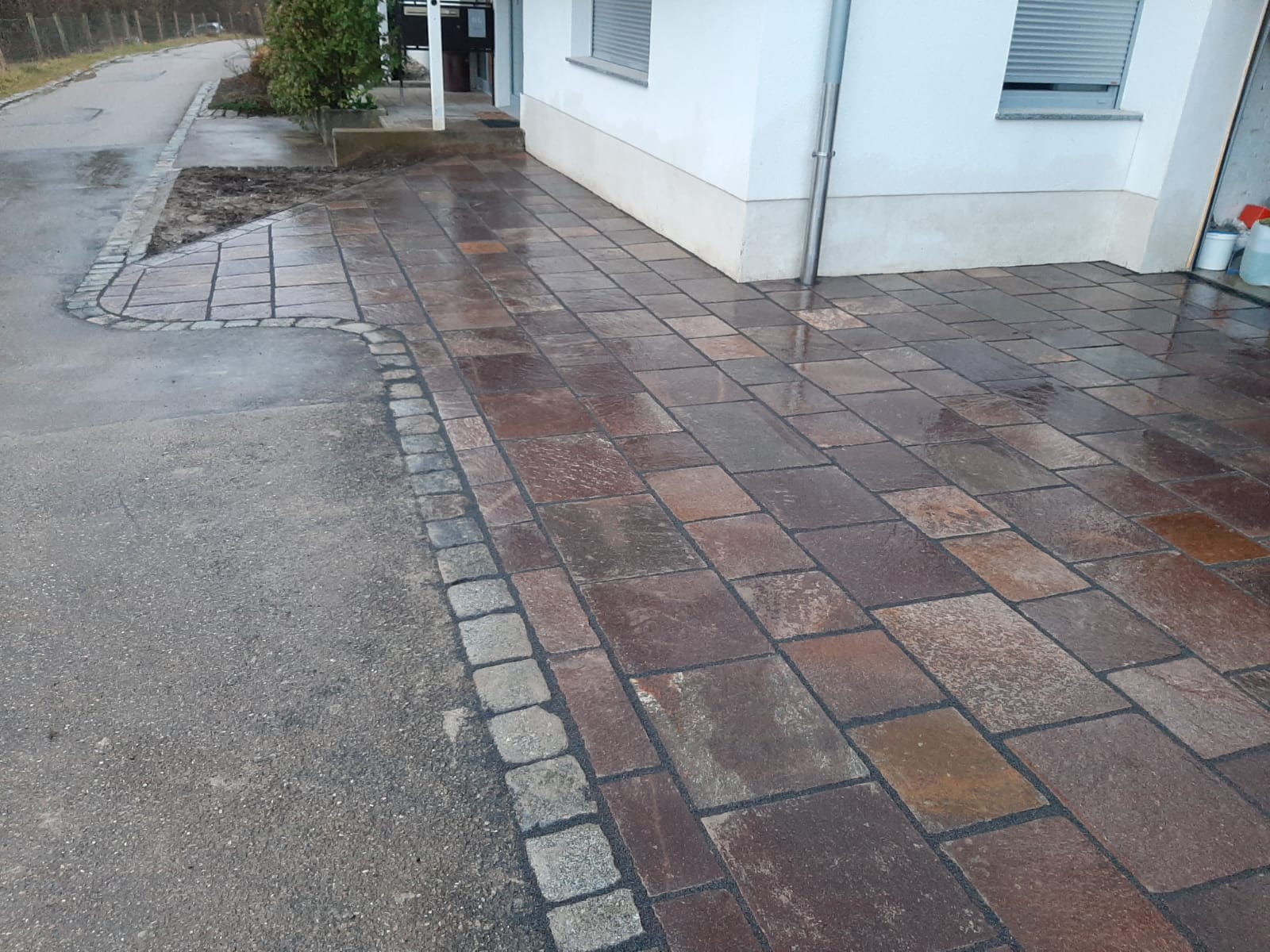 Außenanlagen mit Porphyr-Naturstein, Natursteinmauer und Rollrasen