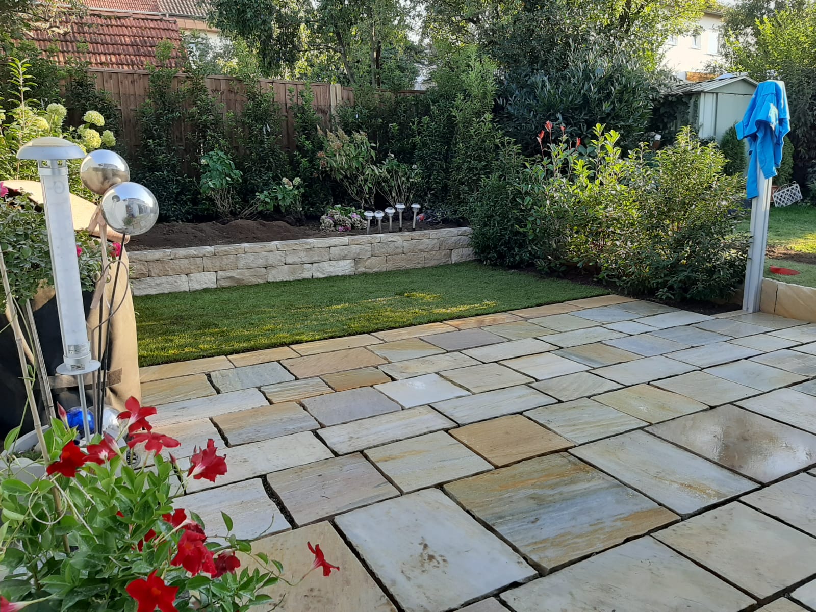 Privatgarten mit Natursteinmauer, Terrasse und Rollrasen in Nürtingen